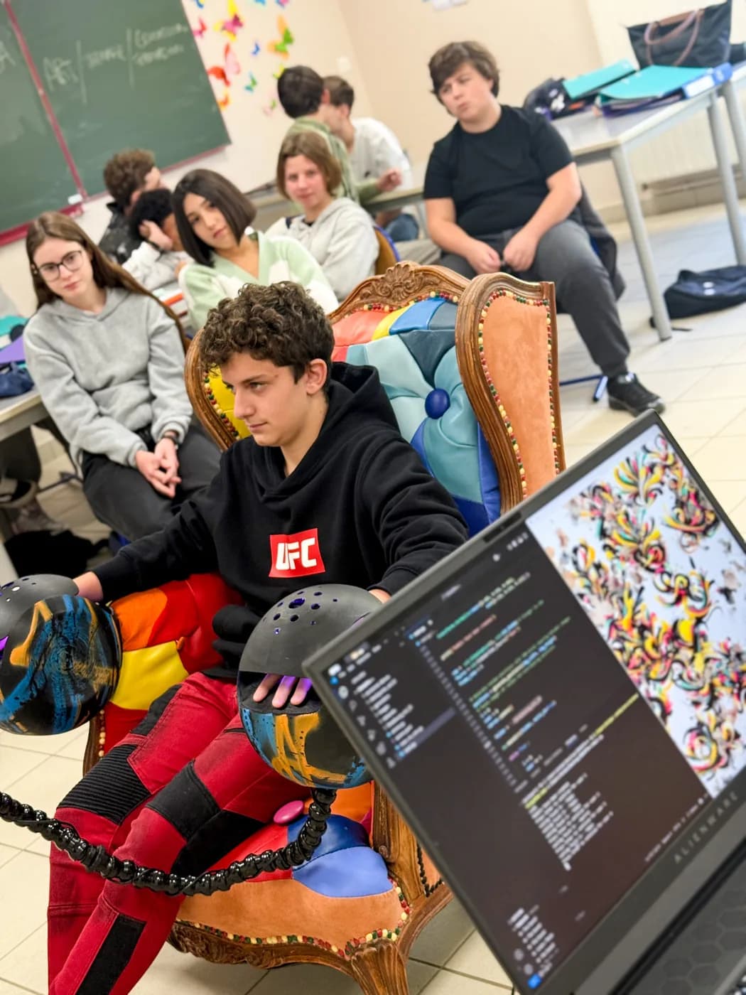 Un élève dans le fauteuil, écran d'ordinateur affichant l'œuvre générée en temps réel
