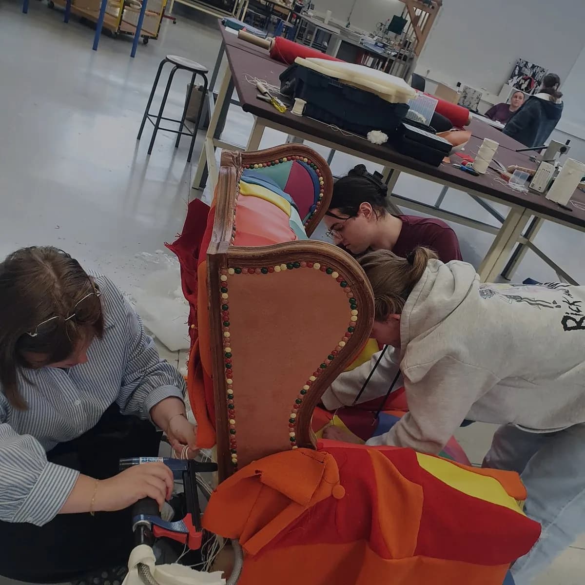 Artisans en train de tapisser le fauteuil signature